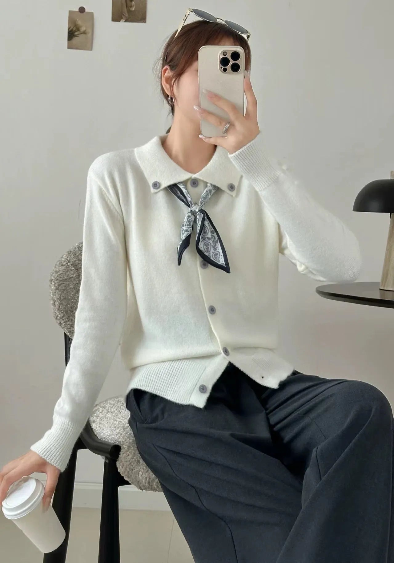 Beige cardigan sweater with a built-in lapel scarf and long sleeves laid flat