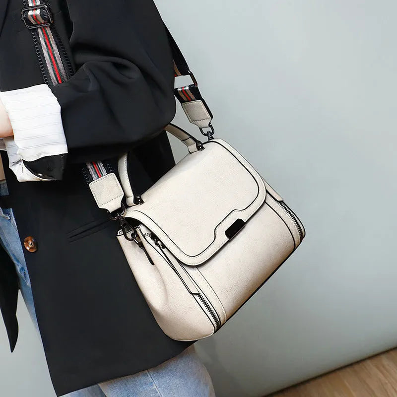 Women's brown genuine leather retro messenger bag with shoulder strap showing organised interior pockets.
