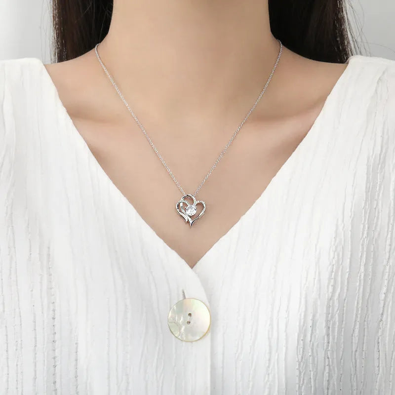 Close-up of a women's heart-shaped pendant necklace in 925 silver with a choice of gold tone finishes.