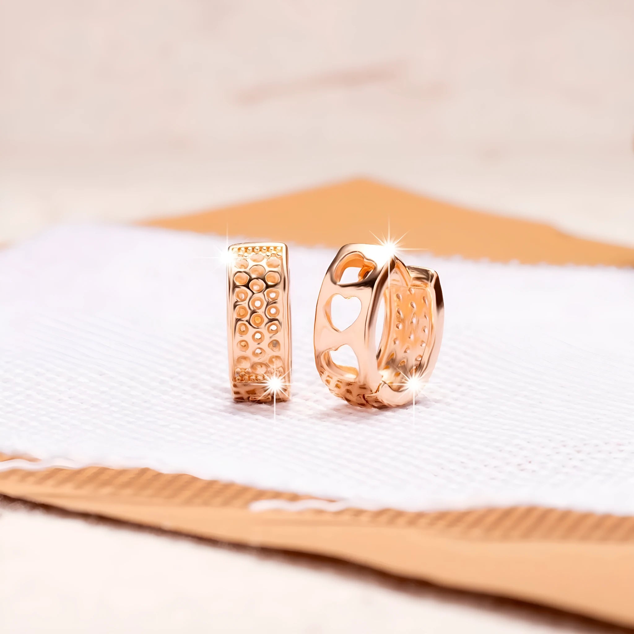 Rose gold electroplated women's earrings with three hollow heart designs in circular frame