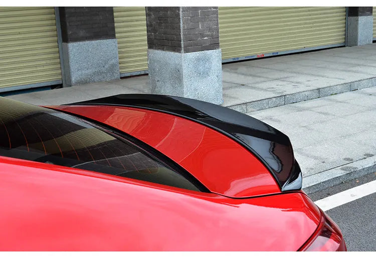 Mazda 3 Axela Exela rear diffuser spoiler tail trim in bright black installed on car bumper.