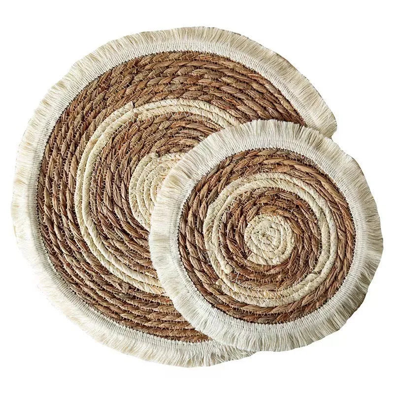 Round natural papyrus placemat with decorative tassels on a wooden table, shown in various sizes.