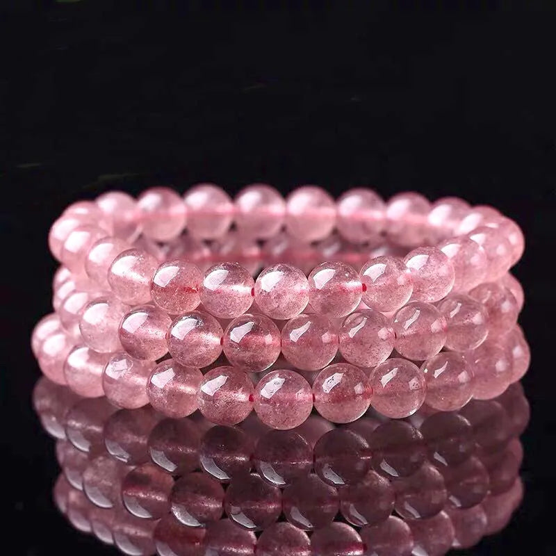 Women's strawberry quartz crystal bracelet with polished beads on an elasticated string.