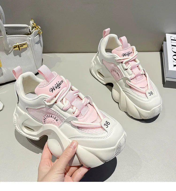 Women's beige sneakers with a cross shoulder strap and thick rubber sole on a white background.
