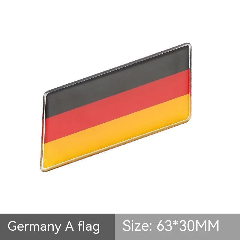 Aluminium metal car sticker with national flag design in a parallelogram shape.