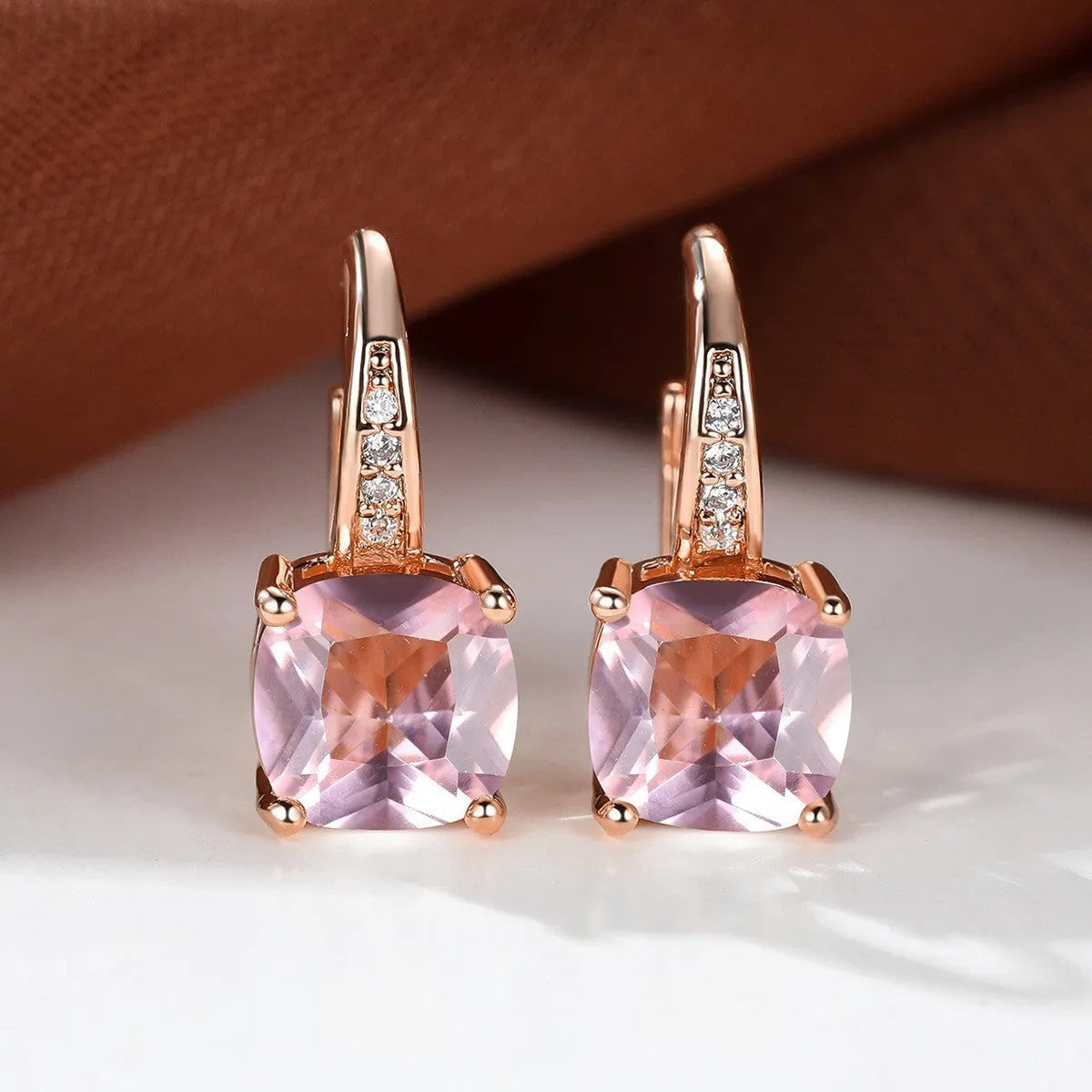Square geometric ear hook earrings with zircon stones in an electroplated copper setting.