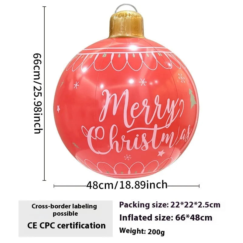 Large red inflatable Christmas ball with snowflake pattern and flash light, shown with a hand pump in a garden setting.