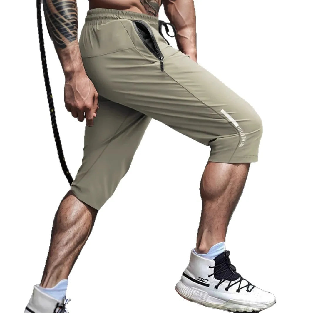 Man wearing grey cropped straight-leg casual sports pants made from quick-dry nylon fabric.