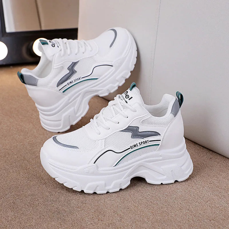 White women's low-top dad shoes with cross straps and lace-up front, showing round toe and rubber sole.