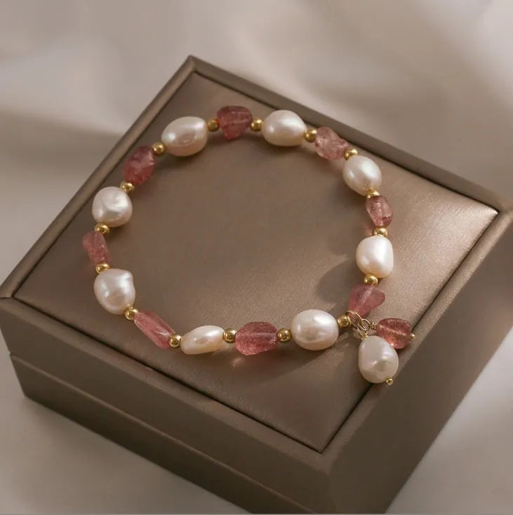 Handcrafted strawberry quartz crystal bracelet with peach blossom design on wrist