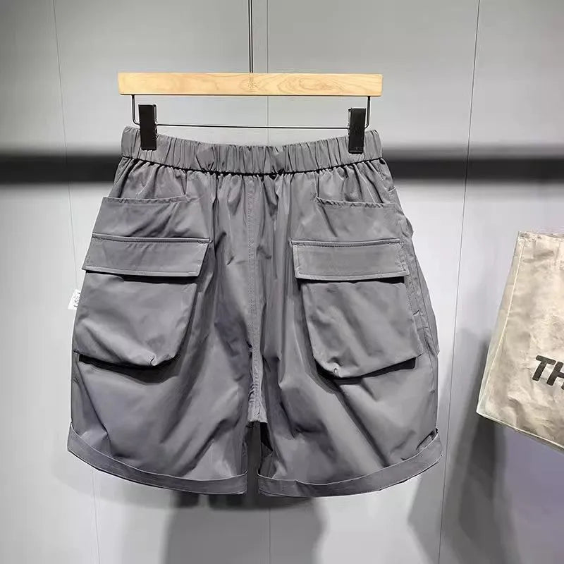 Men's black loose-fit cargo work shorts on a mannequin, showing multiple pockets and above-knee length.