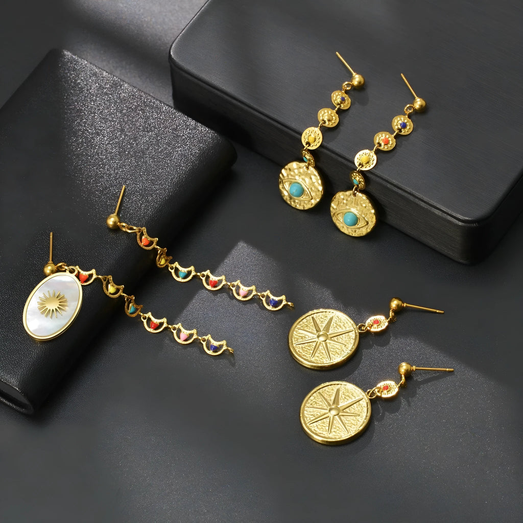 Stainless steel geometric earrings showing eight Awn XINGX, eye, and shell sun designs.