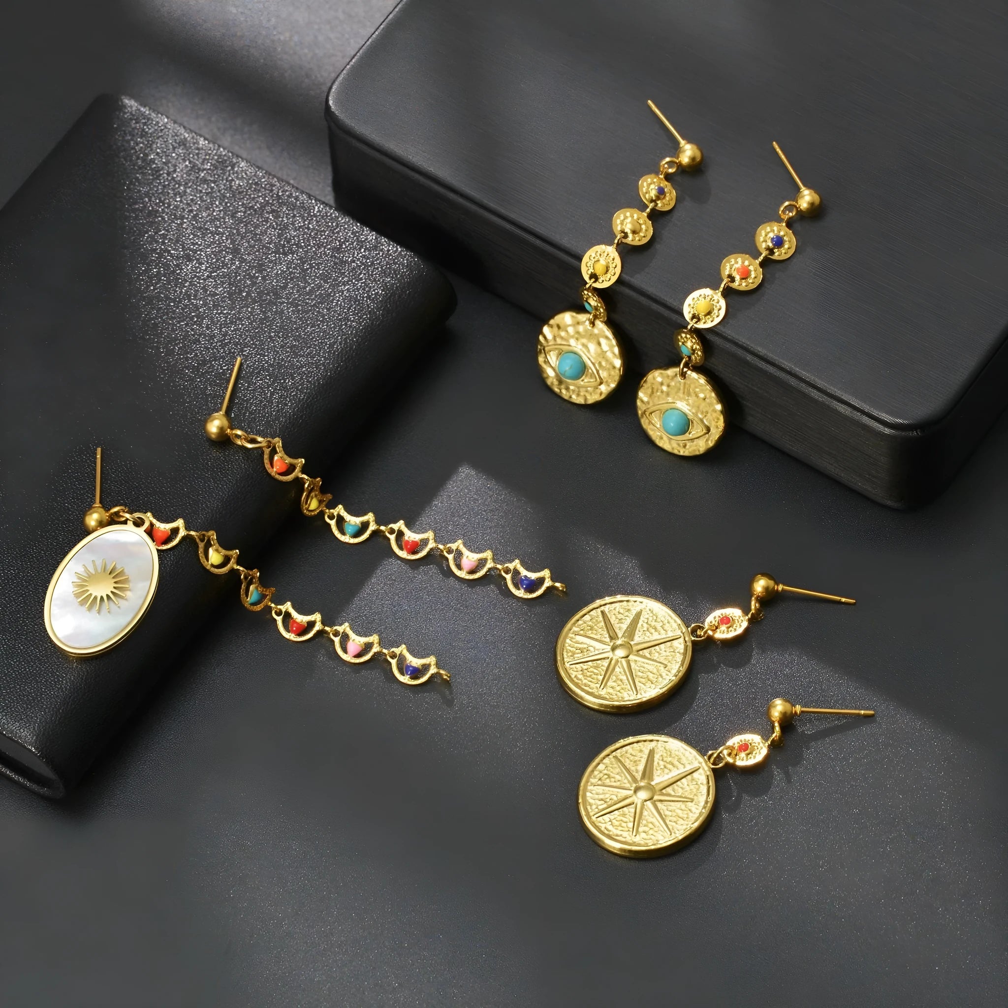 Stainless steel geometric earrings showing eight Awn XINGX, eye, and shell sun designs.
