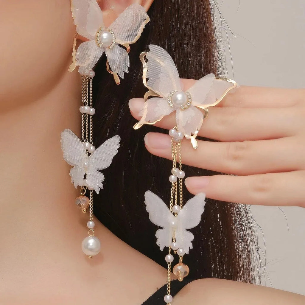 White butterfly-shaped women's earrings with dangling tassels, lace detail, pearl accents, and rhinestone sparkle.