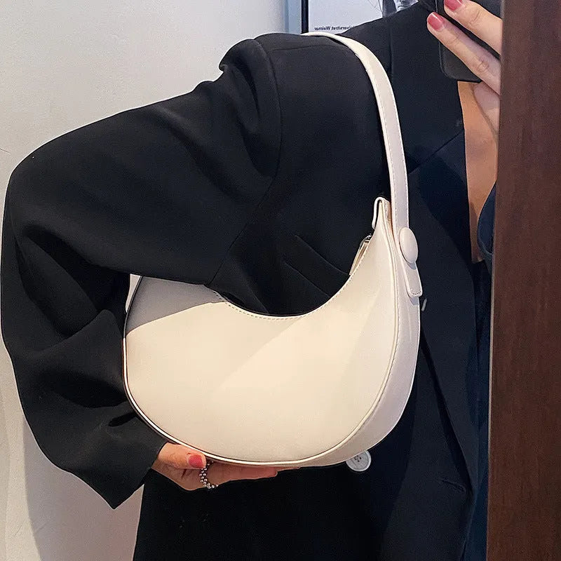 Women's retro brown dumpling-shaped PU shoulder bag showing front pocket and crossbody strap.