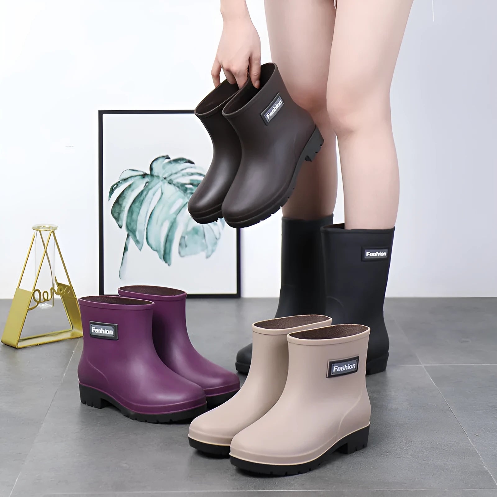Women's mid-calf PVC rain boot in black on a wet surface.