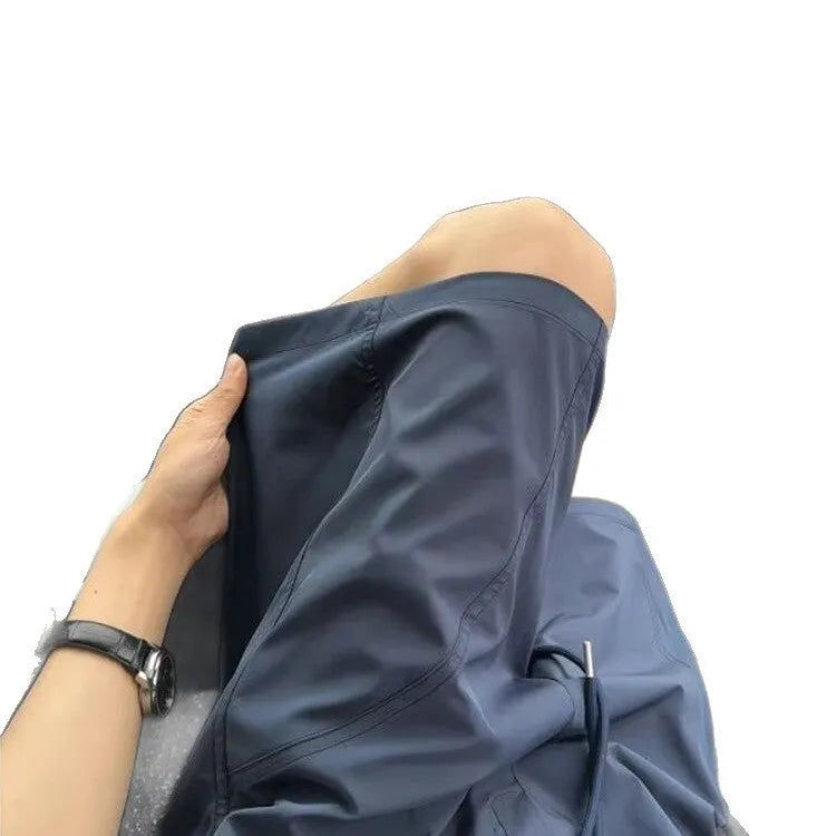 Men's beige polyester sports shorts with elastic waistband, shown alongside black and navy blue colour options.