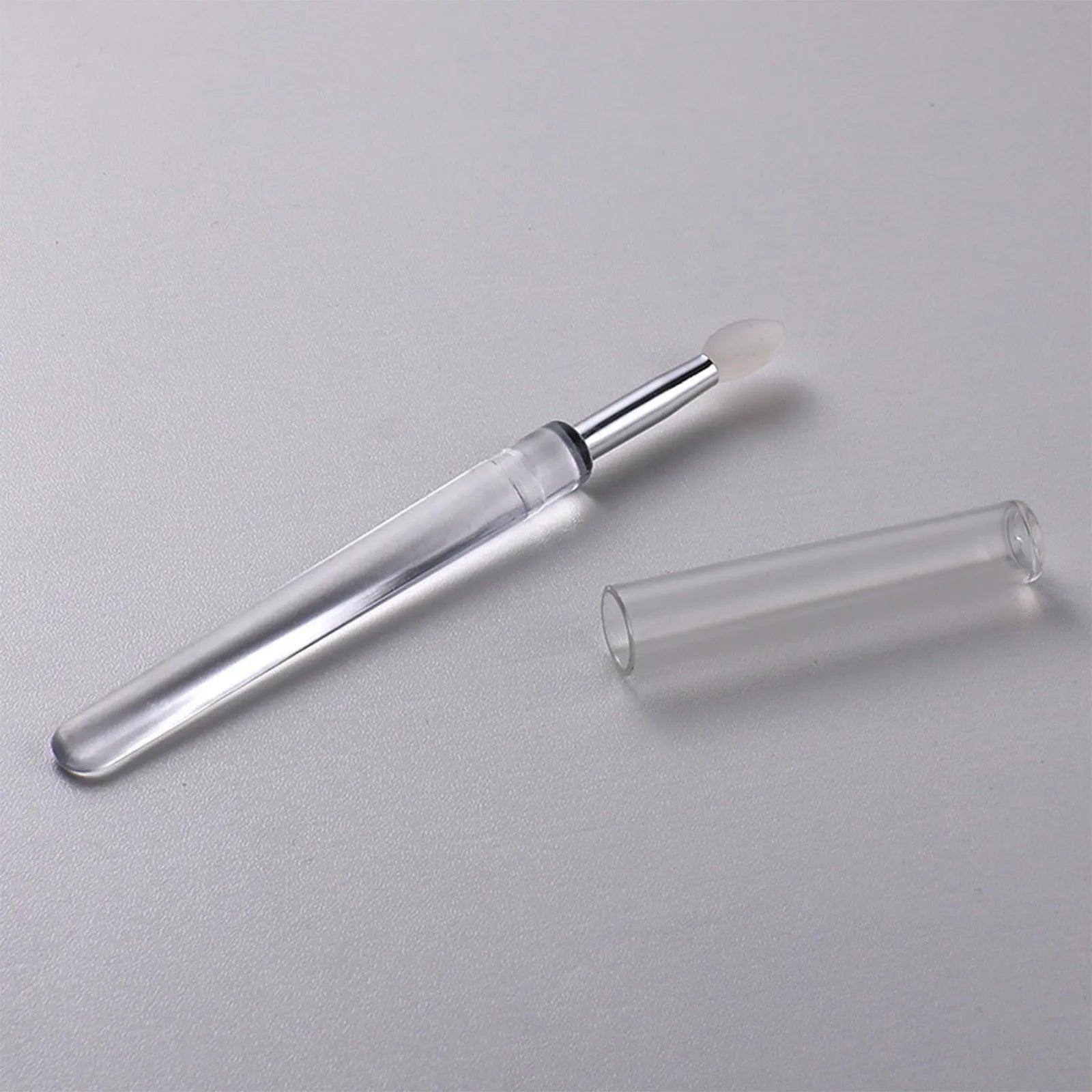 Set of coloured silicone lip brushes with protective caps for applying lipstick and lip gloss.