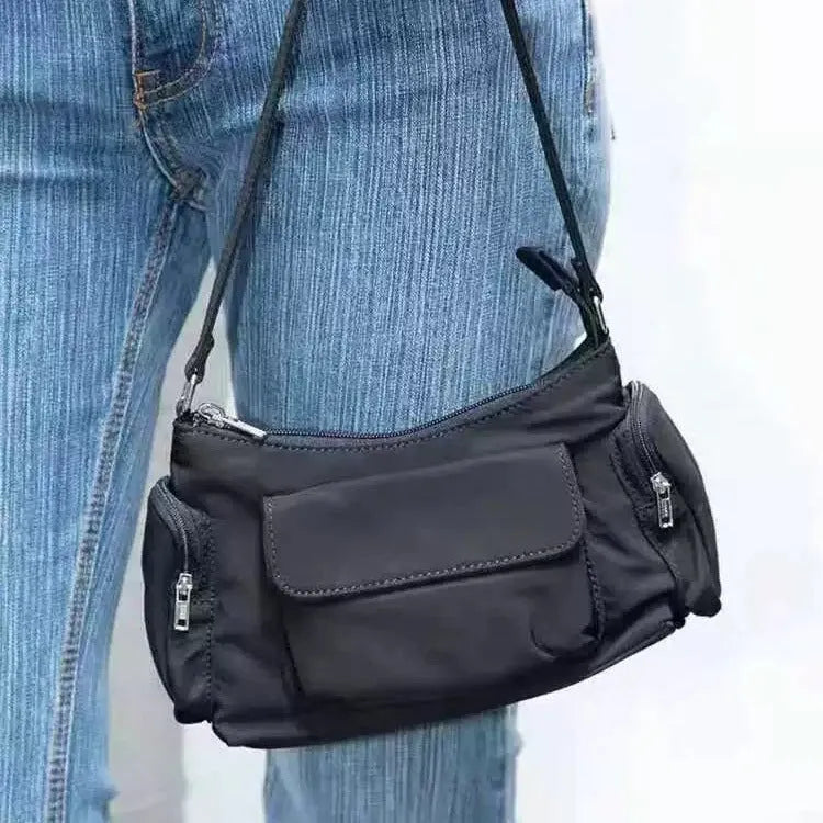 Black women's shoulder bag with two front pockets showing side line stitching detail