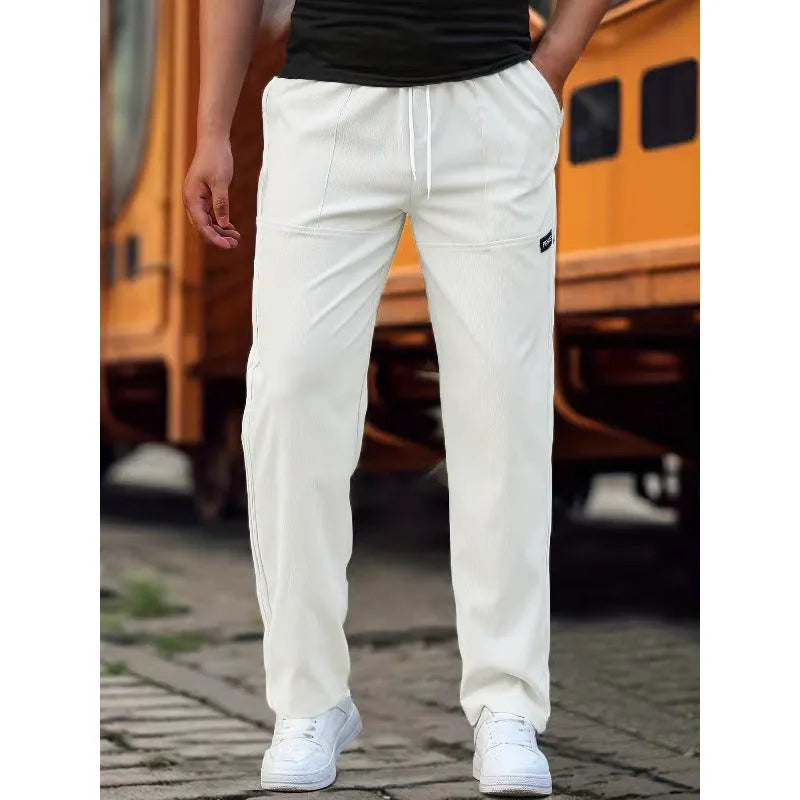 Men's polyester trousers in light grey, shown laid flat, suitable for spring and autumn wear.
