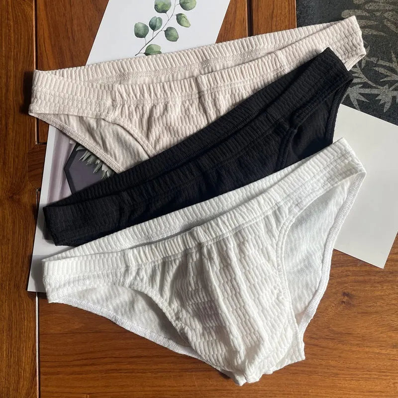 Men's solid colour cotton triangle briefs with a mid-waist waistband on a white background.