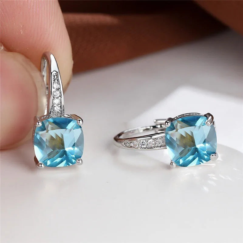 Square geometric ear hook earrings with zircon stones in an electroplated copper setting.