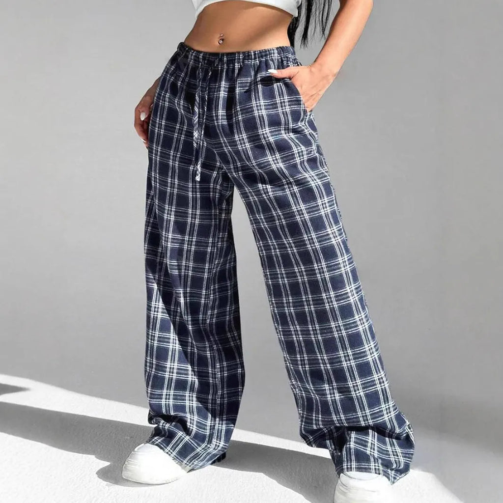 Red women's loose fit plaid trousers with drawstring waist and pockets on a mannequin.