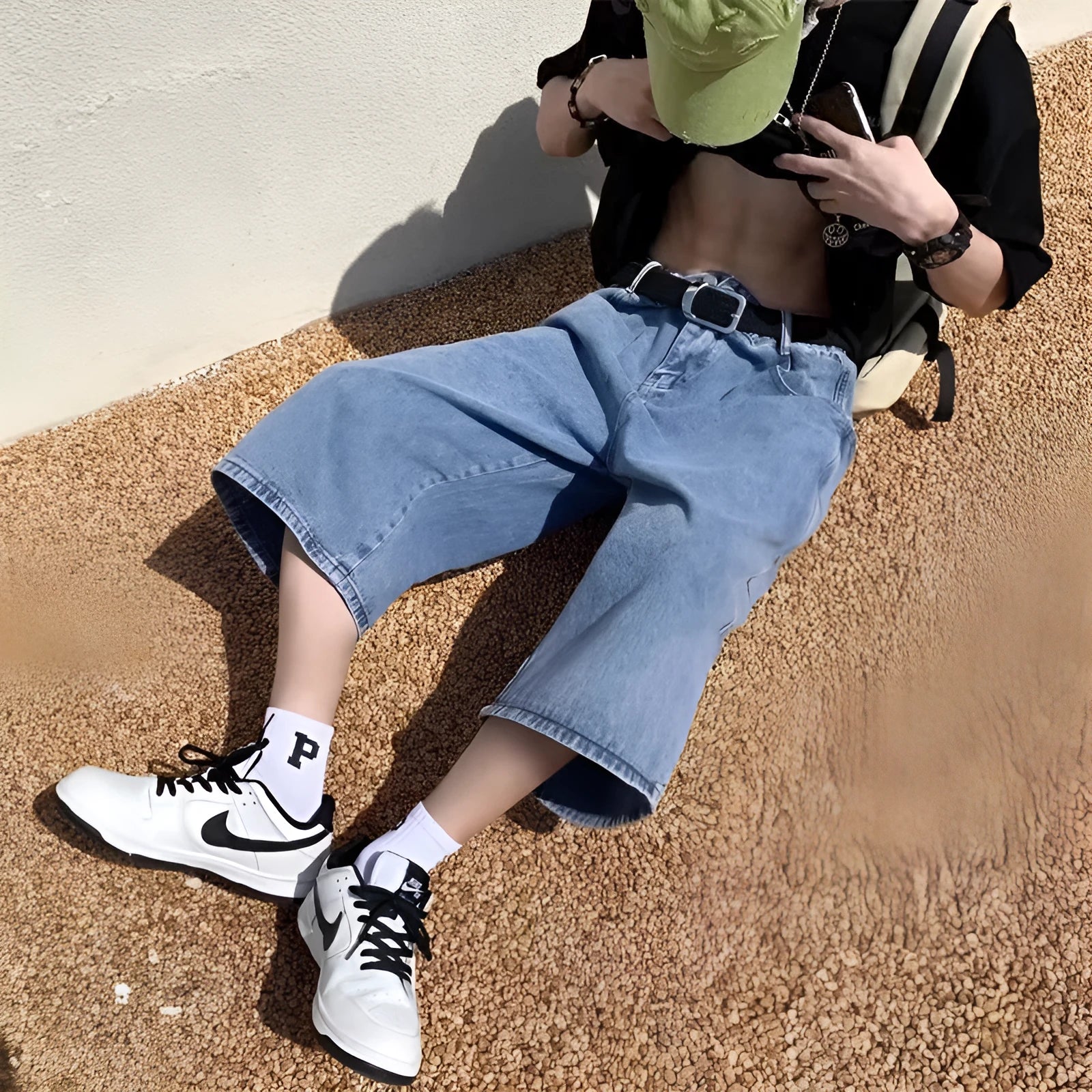 Man wearing blue washed denim pirate-style shorts with cropped length and high waist.