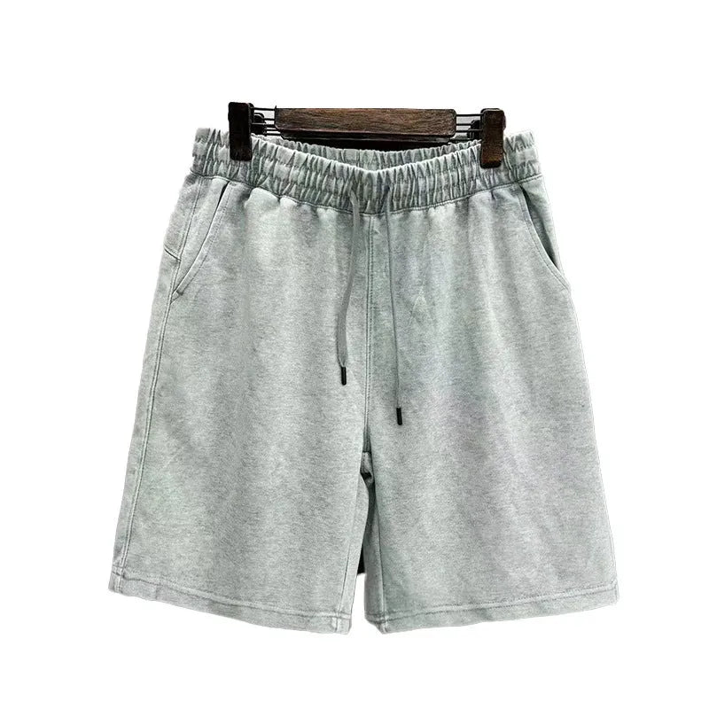 Men's light blue cotton shorts with distressed detailing and a loose, straight-leg fit on a mannequin.