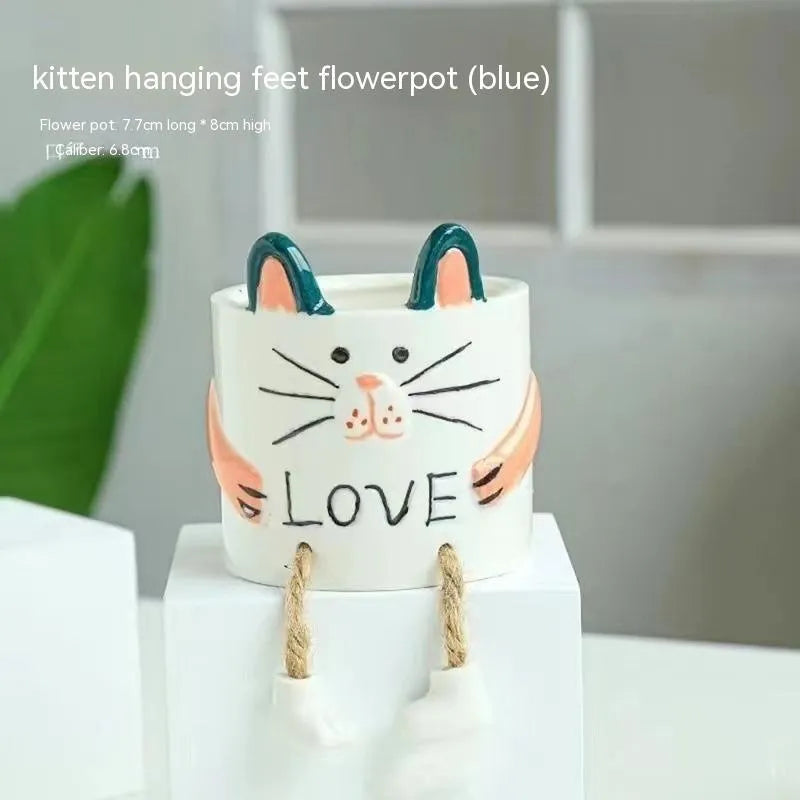 Cartoon style ceramic hanging foot flowerpot for succulent plants on a desktop.