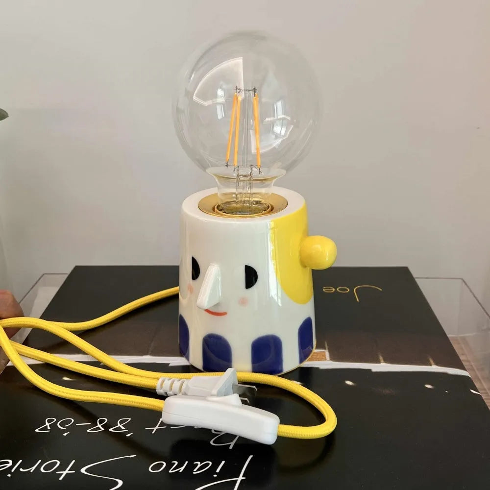 Handmade ceramic table lamp with a ball-shaped headlight on a neutral background.