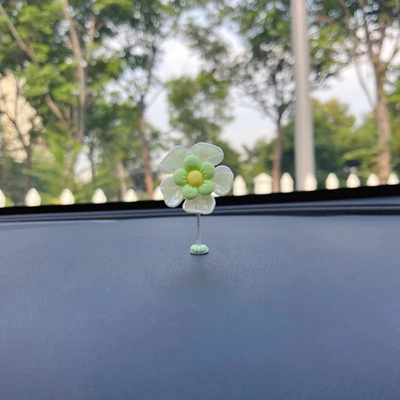 Small colourful plastic car swing decoration hanging from a rear-view mirror.