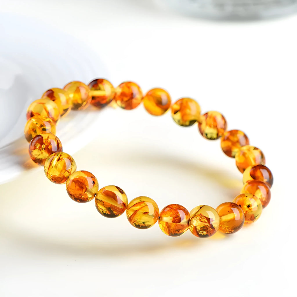 Natural yellow piebald amber bracelet with geometric design and polished Baltic amber beads