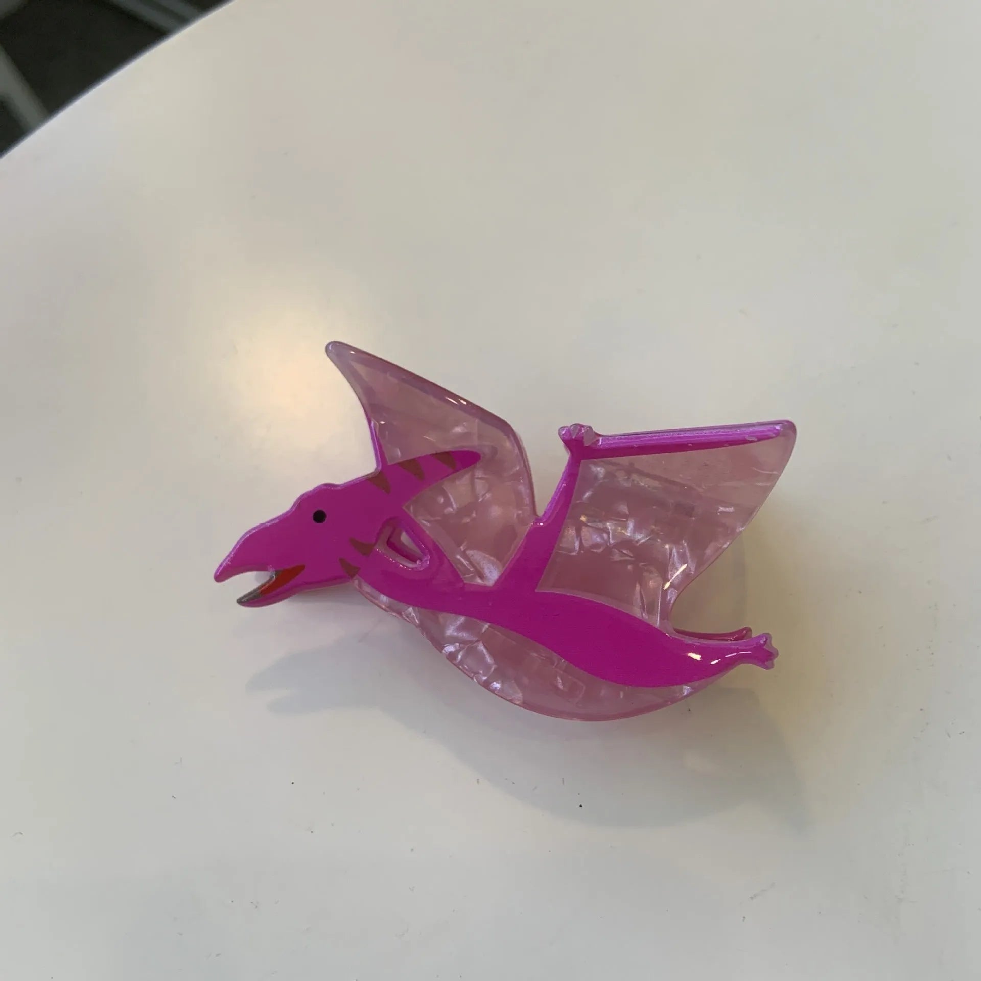 Acrylic dinosaur jaw grip hair clip showing six colour variations with prehistoric creature designs