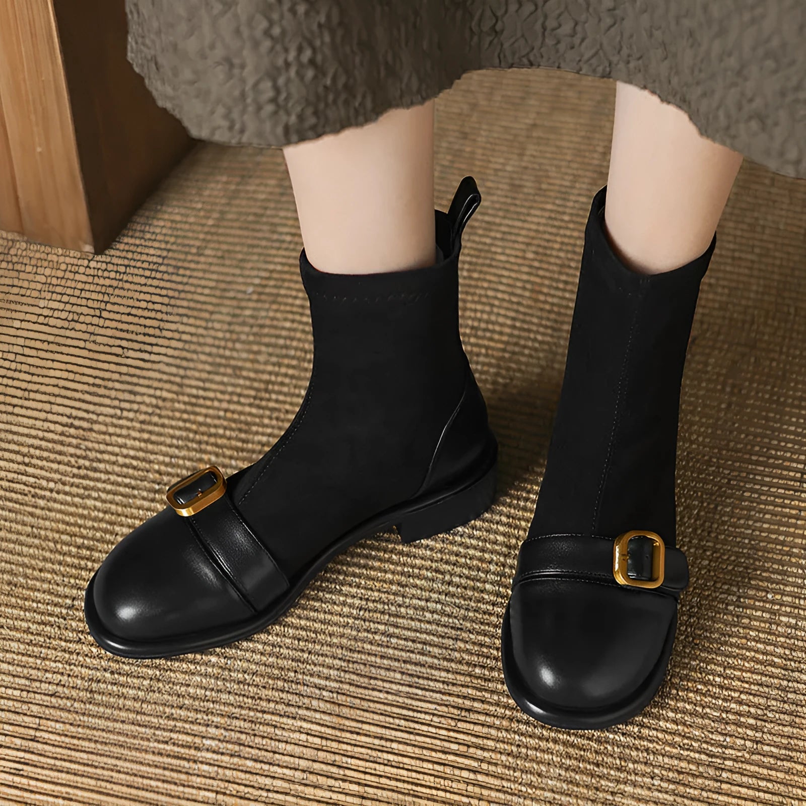 Black women's low heel Martin boot with belt buckle stitching and lace-up front on a rubber sole.