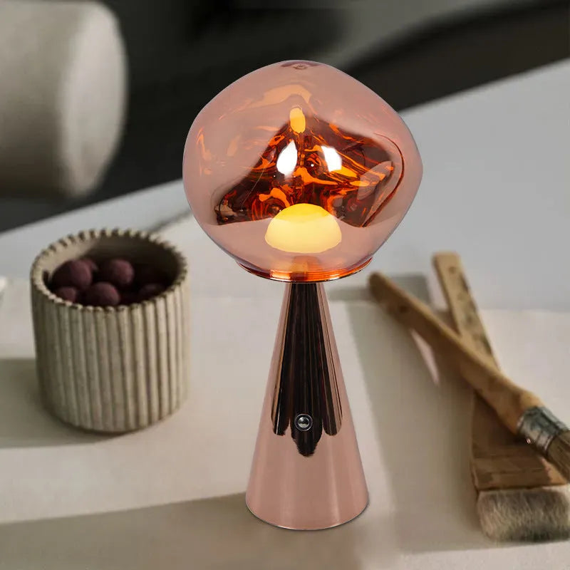 Volcanic lava mini table lamp with metal holder in gold finish, USB magnetic charging, on a bedside table