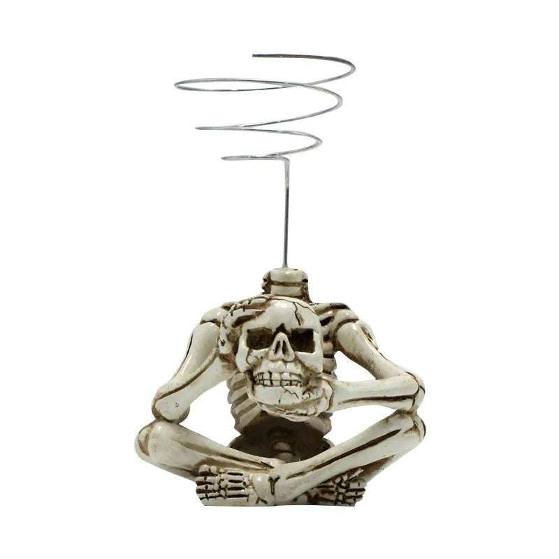 Gothic skull-shaped resin bracket for holding a soilless tillandsia air plant, with separate iron wall mount.