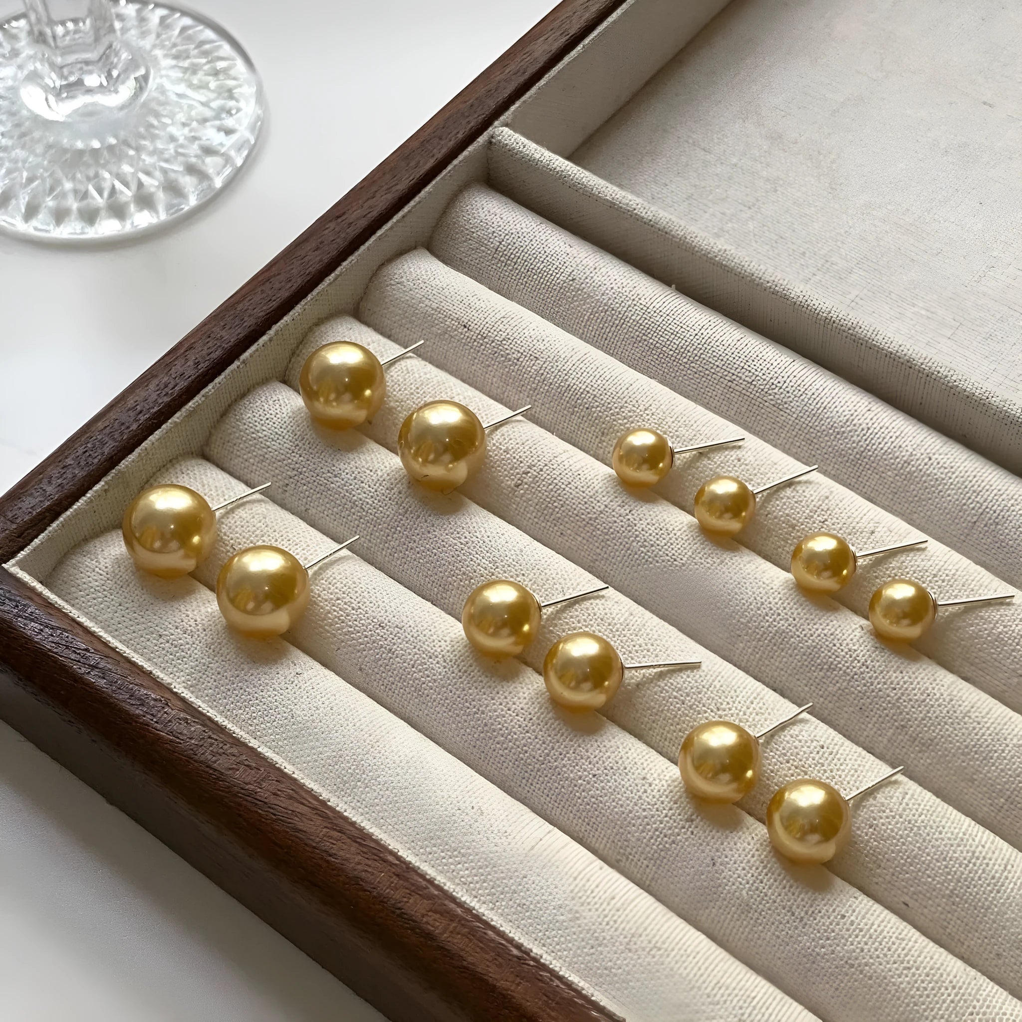 Geometric pearl stud earrings with an eight-point star setting, shown in silver.