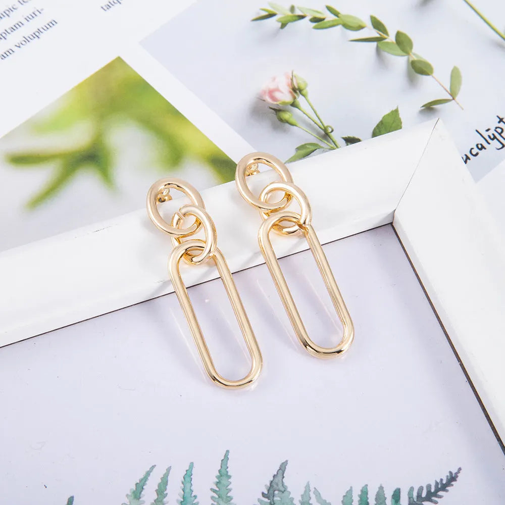 Geometric sterling silver tone hoop earrings for women with a ring and line design.