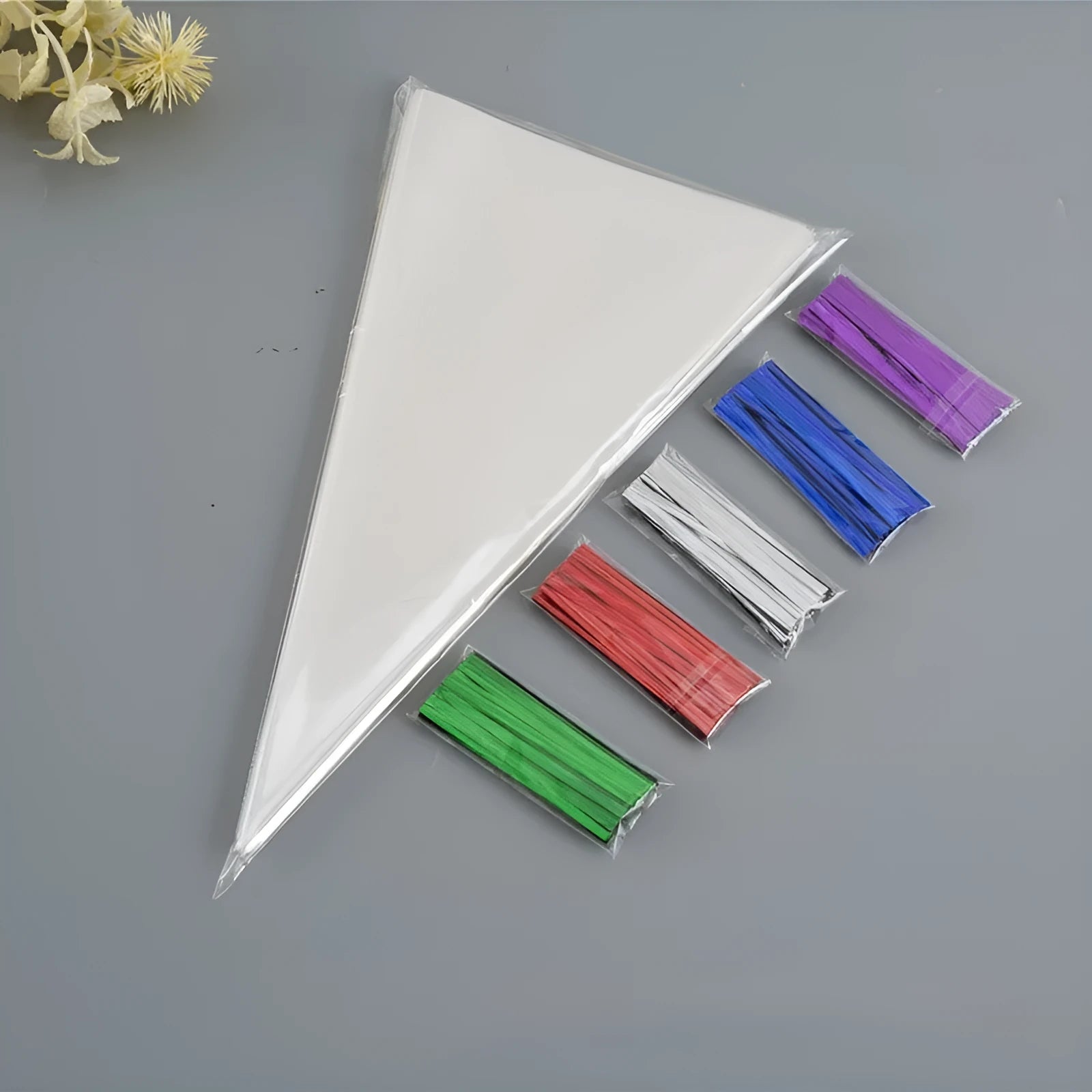 Clear triangle-shaped plastic packaging bag with a white tie wire closure, shown in three different sizes.