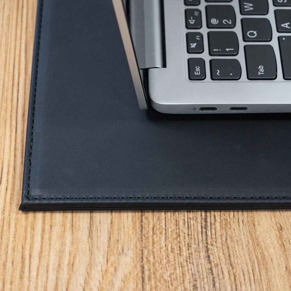 A heat-insulating anti-radiation tablet pad in blue colour with a non-slip base, placed under a laptop.