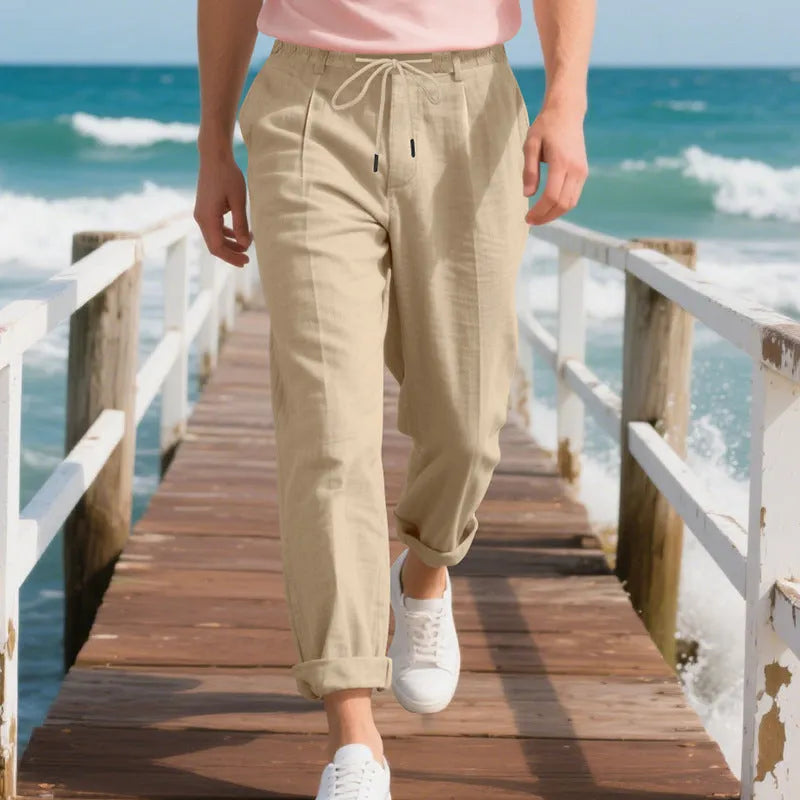 Men's loose-fit straight-leg linen trousers in light khaki colour with a drawstring waist.