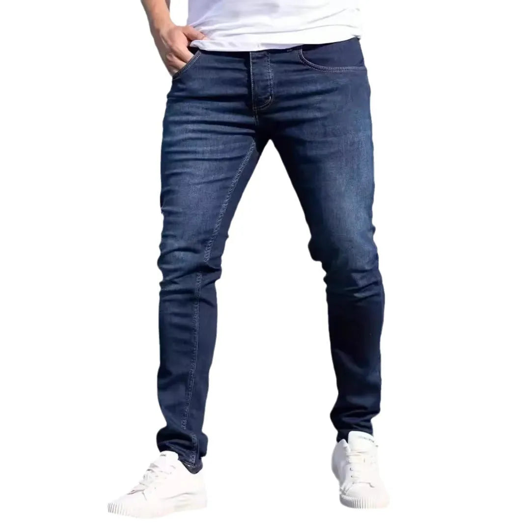 Men's dark blue slim-fit skinny casual jeans on a neutral background