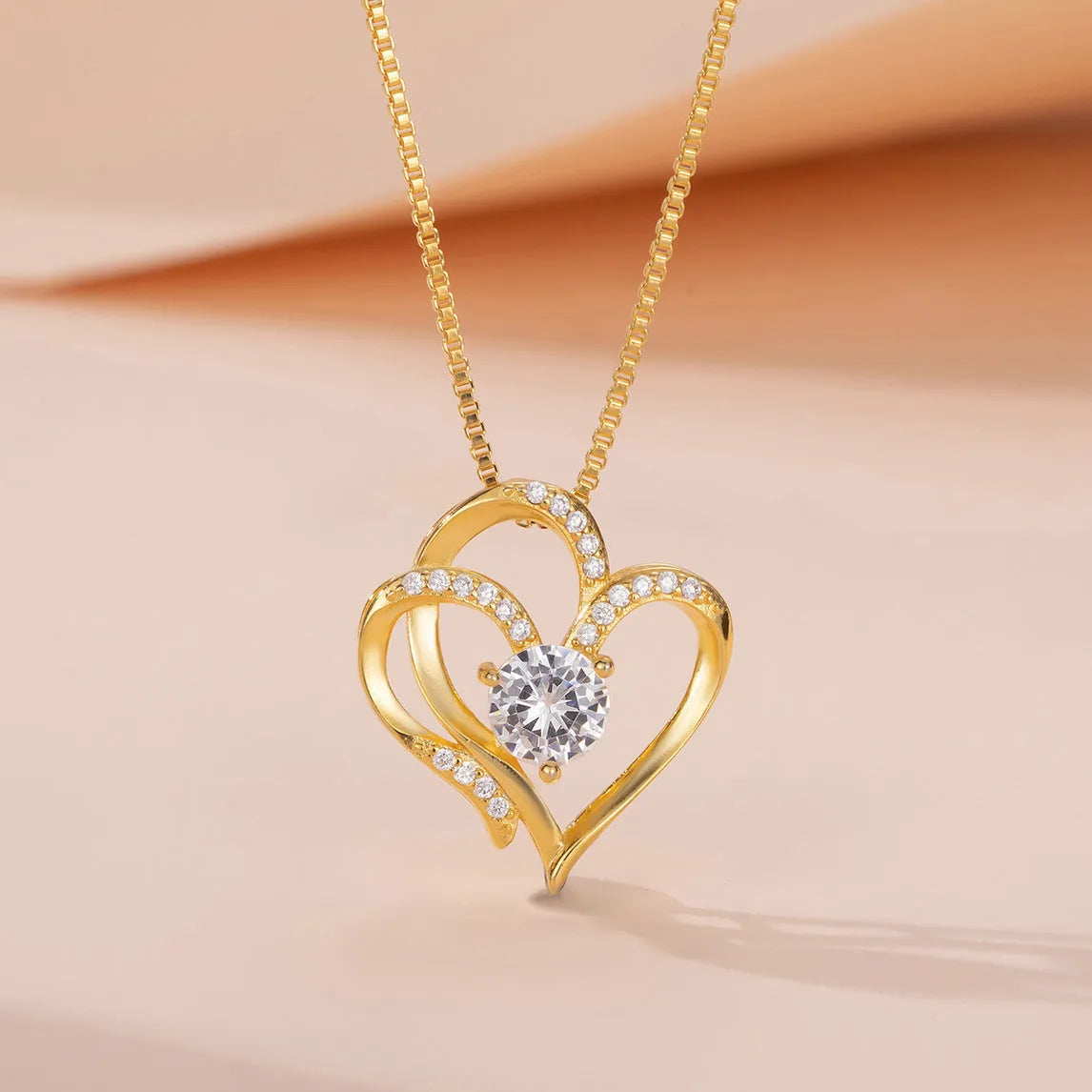 Close-up of a women's heart-shaped pendant necklace in 925 silver with a choice of gold tone finishes.