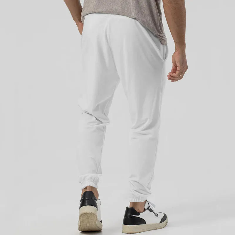 Men's grey casual track sweatpants with loose tapered cut and straight leg design, elastic waistband