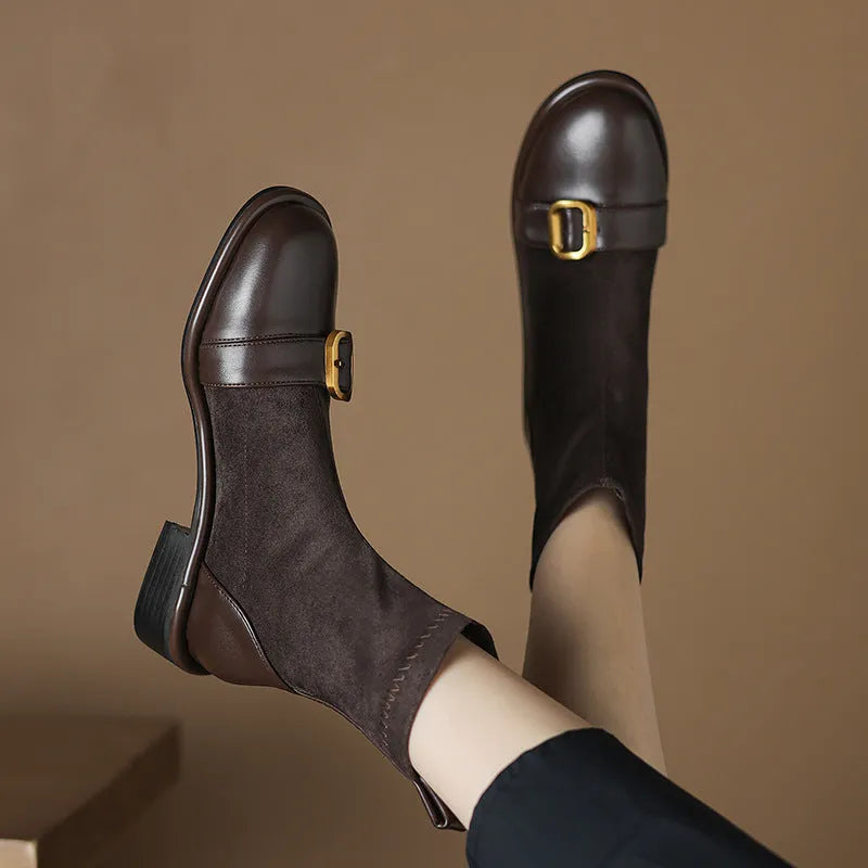 Black women's low heel Martin boot with belt buckle stitching and lace-up front on a rubber sole.