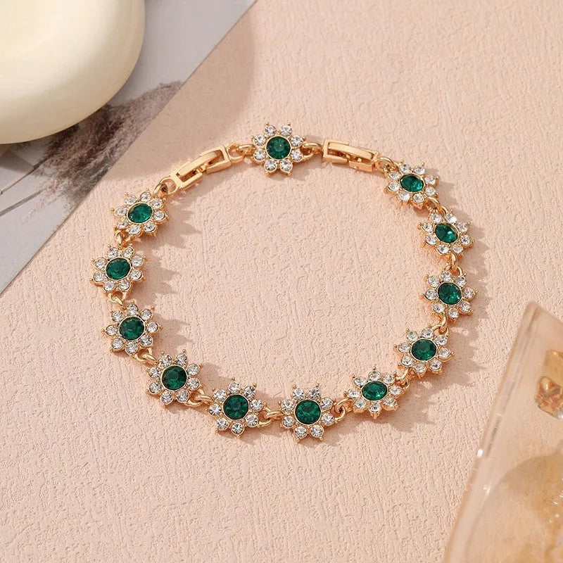 A gold or silver electroplated zinc alloy flower bracelet with coloured gems.