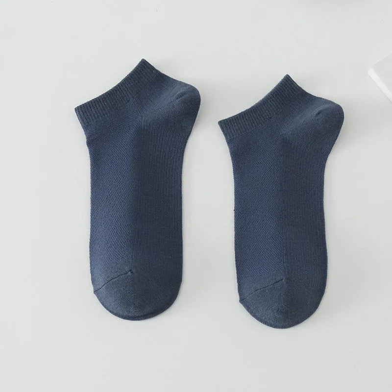 Solid colour low-cut polyester boat socks for men on a neutral background.