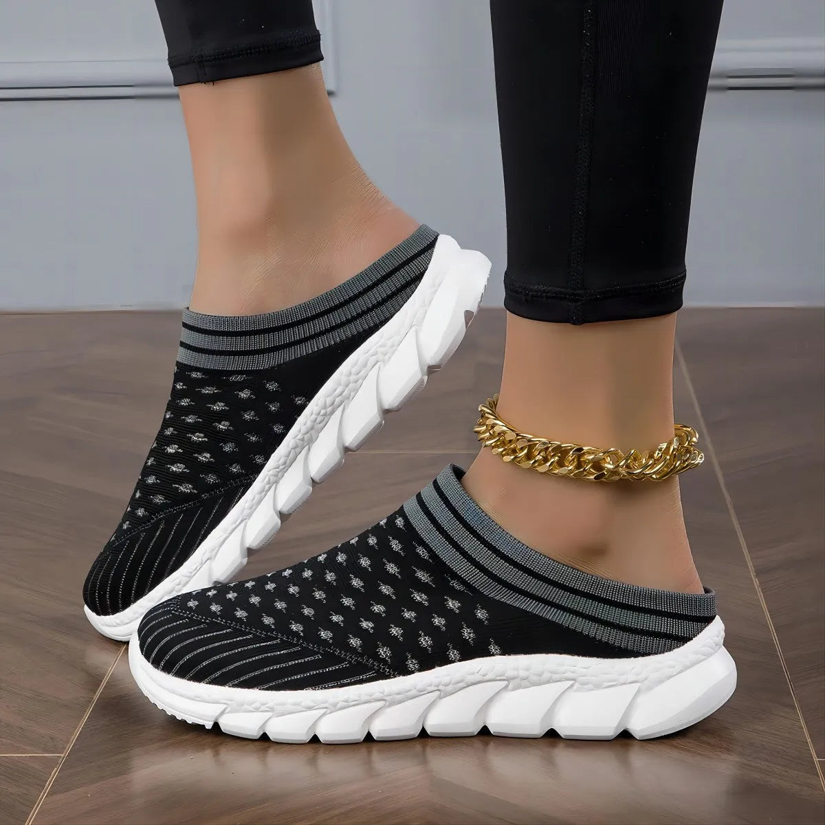 Women's black Flyknit slipper shoes with striped pattern and hollowed-out design on a viscose sole.
