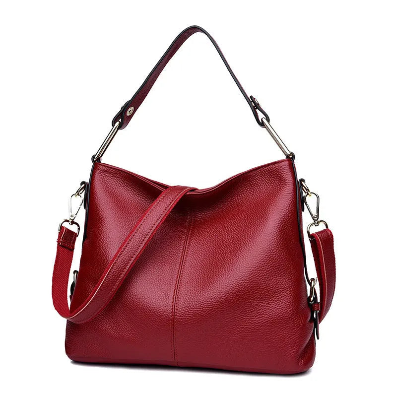 Genuine leather vertical square crossbody bag in black showing outer pocket and structured shape.